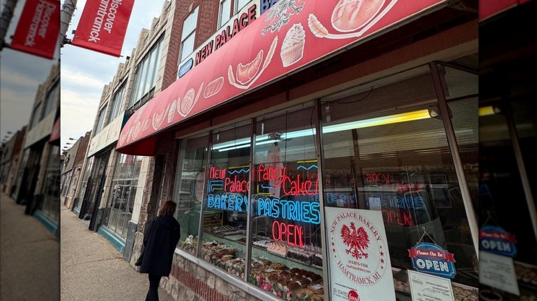 Person walking in front of New Palace Bakery in downtown Hamtramck