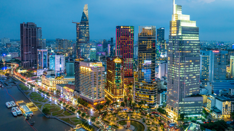 Aerial view of high-rise buildings lining a river at dusk