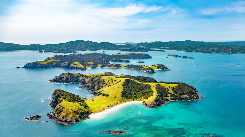 Lush, craggy islands rise out of aquamarine waters in New Zealand.