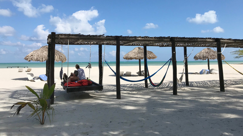 A couple enjoying the day beds on an uncrowded white sand beach in Isla Pasion