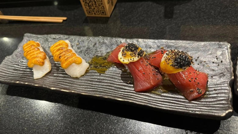 Plate at Maido with four pieces of sushi-grade fish