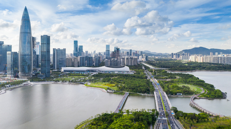 Shenzhen city landscape with skyscrapers overlooking water, green space, and a bridge