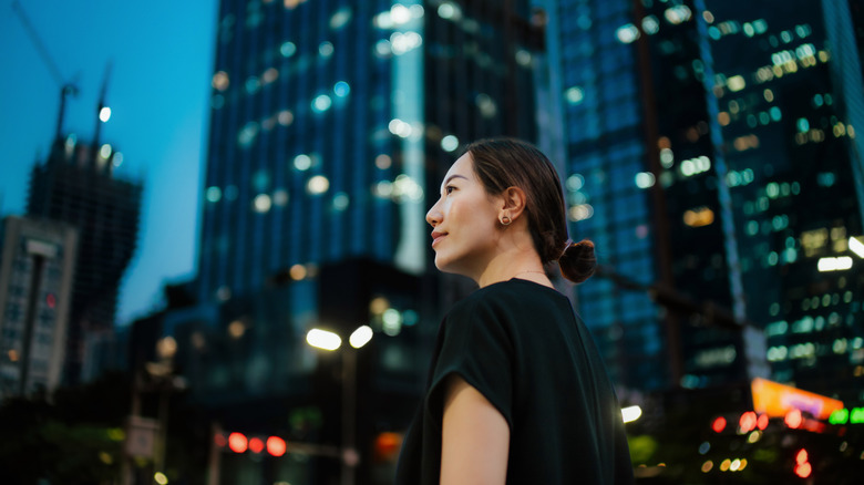 Person in profile against a backdrop of high-rise buildings