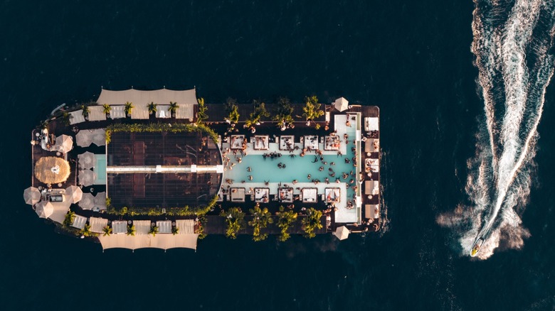 Aerial view of a speedboat approaching Yona Beach Club, which is floating in the Andaman Sea off of Phuket, Thailand