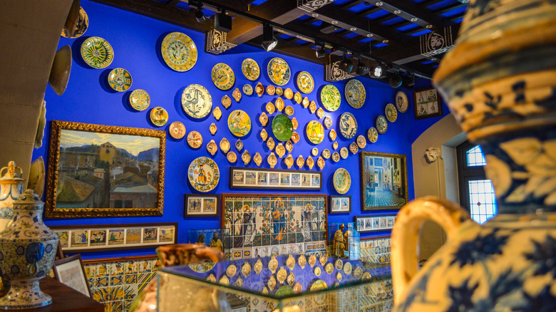 The elaborate showroom of museu del cau ferrat with paintings and decorative plates on the wall