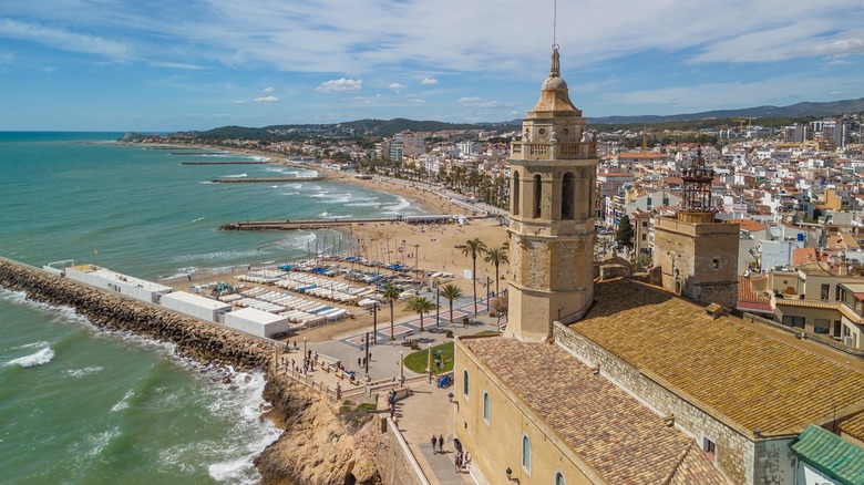 An aerial view looking down at the Sitges church steeple and miles of beaches