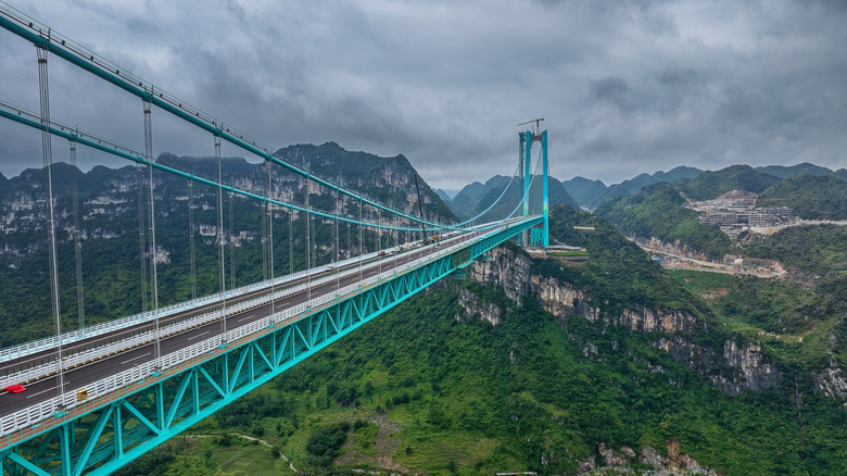 The blue Huajiang Grand Canyon Bridge over a deep gorge and river in China's Guizhou province