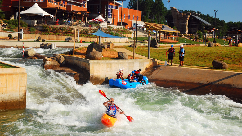 Kayaker and rafters on man-made river
