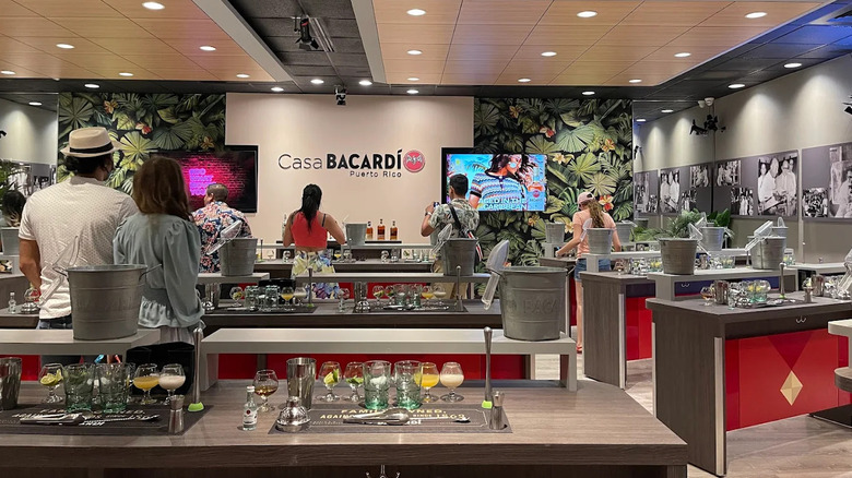 People standing at bar-top stations at a Casa Bacardi Mixology Class