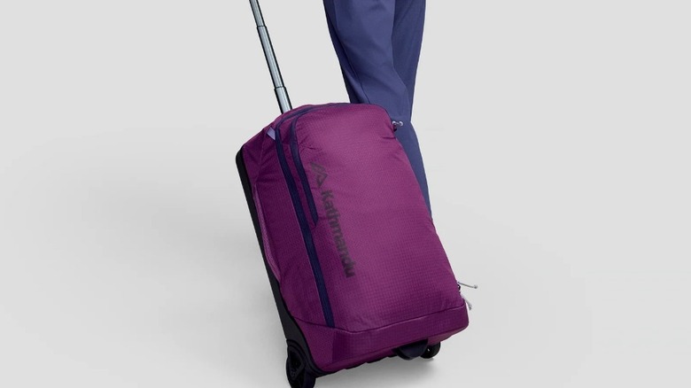 Traveler shows Kathmandu's Feather Flight Carry-On suitcase