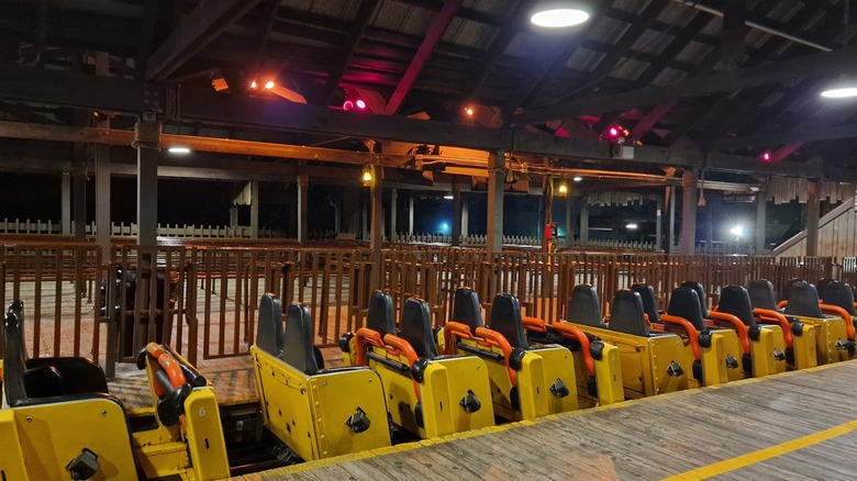 Empty roller coaster cars at night at the platform The Beast