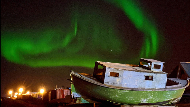 The northern lights dancing above a boat in Utqiaġvik, Alaska.