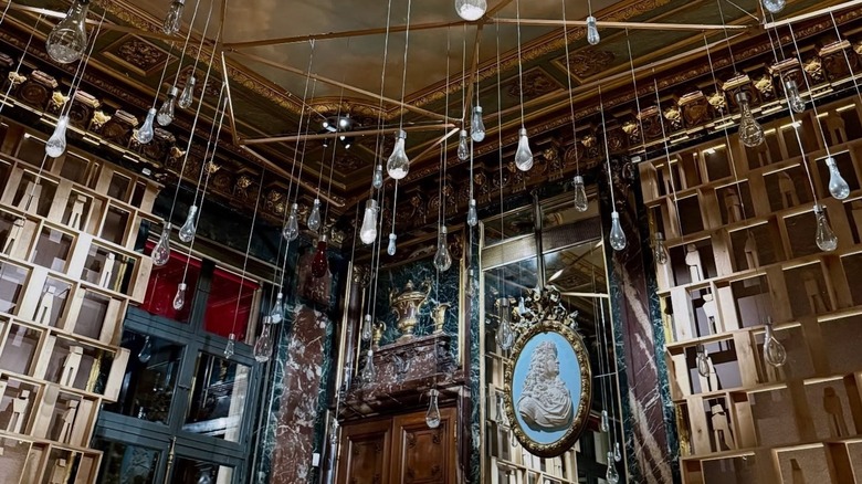 Crystal light fixtures against wooden shelves Ducasse Baccarat Paris