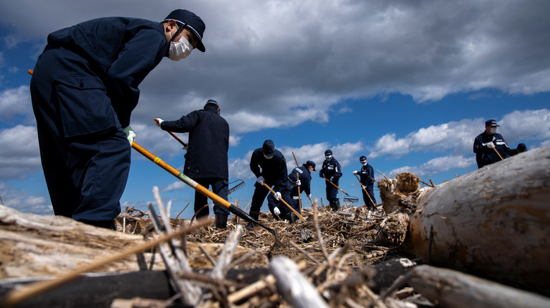 Rescue workers search for people in the rubble caused by an earthquake in Japan