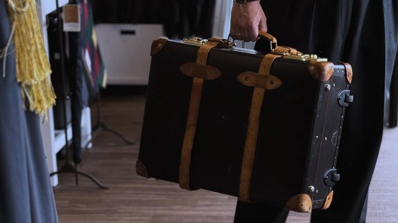 A man holds a Globe-Trotter suitcase