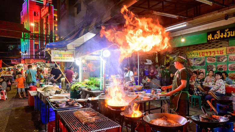 A chef fires up dishes in a street food market in Bangkok's Chinatown.
