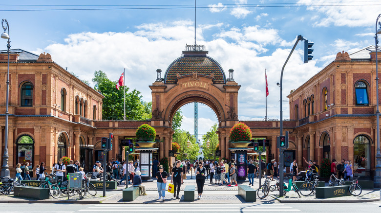 Arched entrance to Tivoli Gardens flanked by buildings on each side, guests milling around square