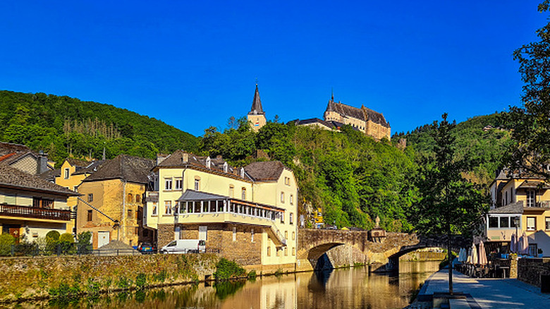 The village of Vianden in Luxembourg, seen from the Our River looking up to the castle on the hill above the town.