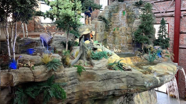 The interior of Outdoor Adventure Center with a manmade cliff, waterfall, and fake animals