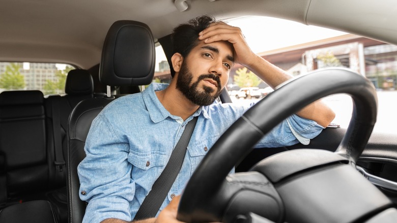 A frustrated man sitting in traffic inside a vehicle