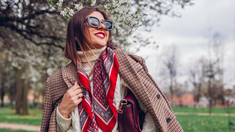 Woman in coat and sunglasses with silk scarf