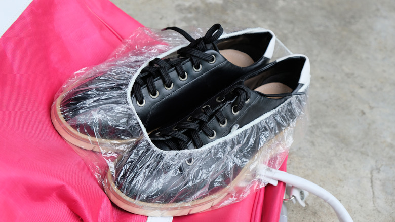 Shower cap wrapped around a pair of shoes for travel