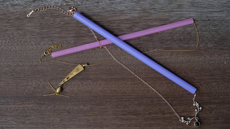 Two necklaces threaded through two straws to keep them from tangling