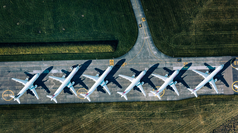 Overhead view of six planes parked on a runway.