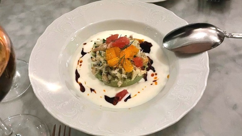 A complex dish of food with a spoon pointing toward it at Kindred restaurant in Charlotte, North Carolina
