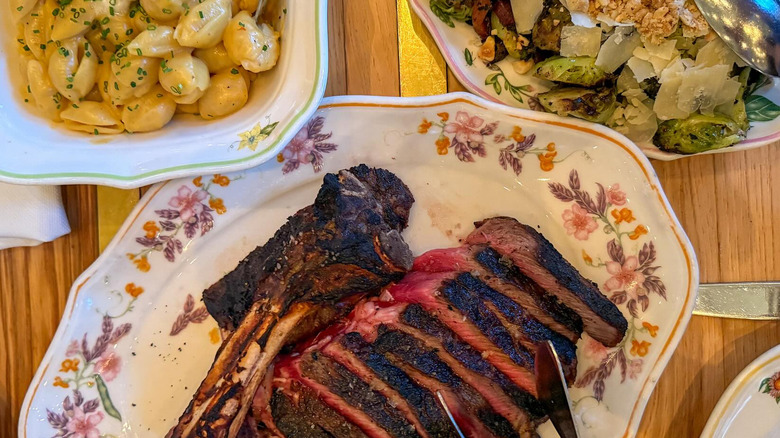 Dishes of steal, pasta, and salad at Supperland restaurant in Charlotte, North Carolina