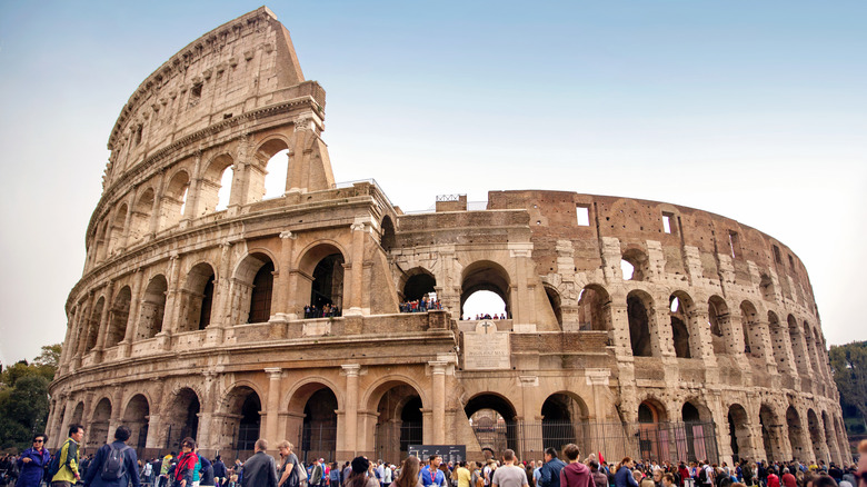 Crowds of tourists surround the Colosseum in Rome