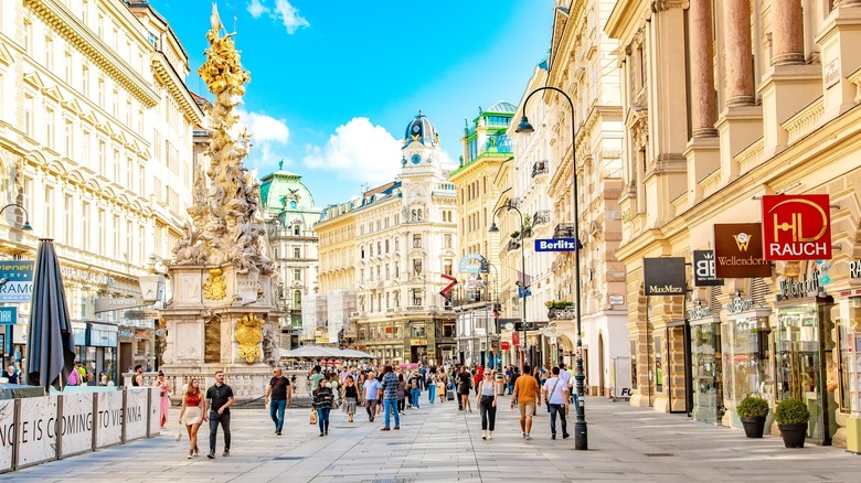 People walking down a sunny boulevard in Vienna, Austria