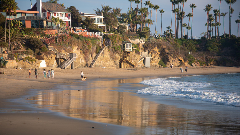 People strolling along the sand at Crescent Bay Beach in Laguna