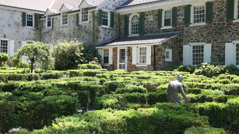 Appleford Estate in Villanova, with a large stone building behind box hedges surrounding a statue of a woman