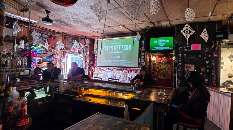 People sitting at bar at Dirty Franks in Philadelphia, with paper snowflakes and televisions visible