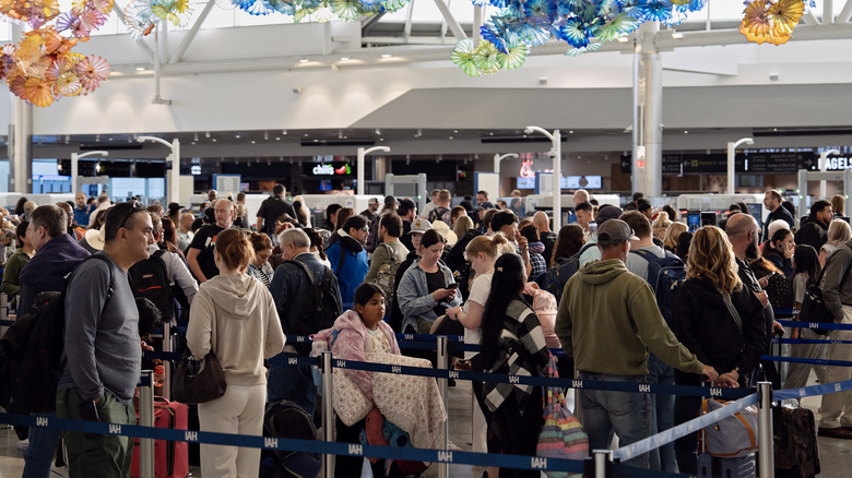 a large group of travelers wait in a snaking line to pass the security checkpoint at the George Bush Intercontinental airport