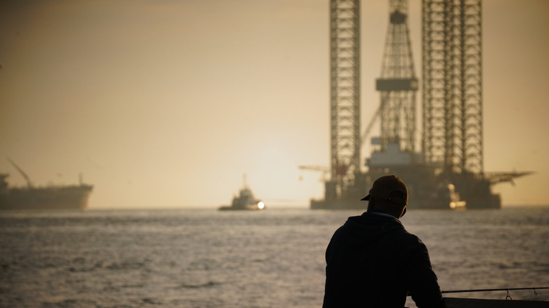 Jack Up Rig in the Gulf of Mexico with the silhouette of fisherman looking on.