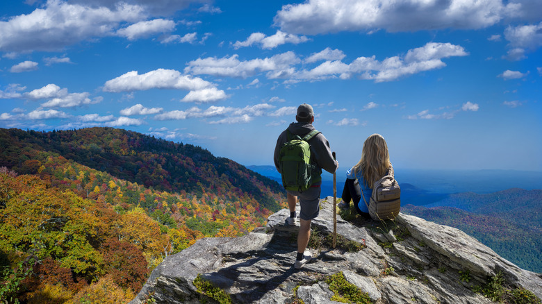 Two hikers look out over a fall view in the Blue Ridge Mountains