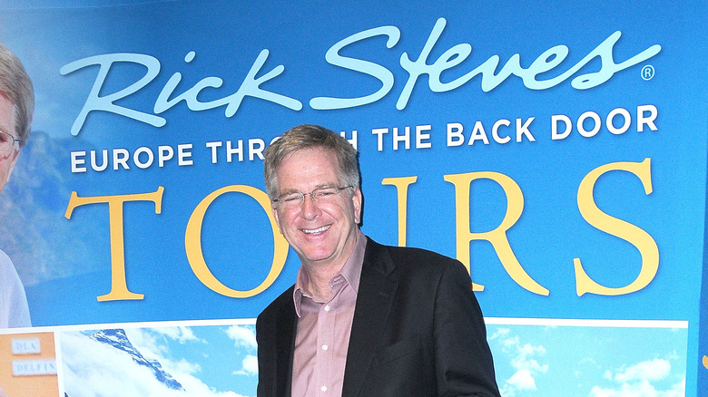 Tour guide Rick Steves poses with a poster