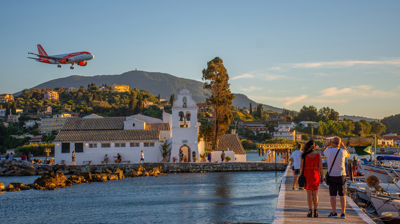 An EasyJet plane landing in Corfu, Greece over the water in the evening.