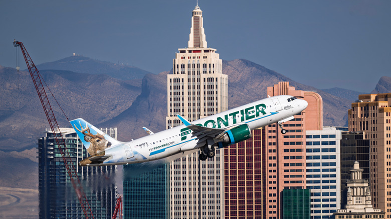 Frontier jet taking off from Harry Reid International Airport over buildings in Las Vegas