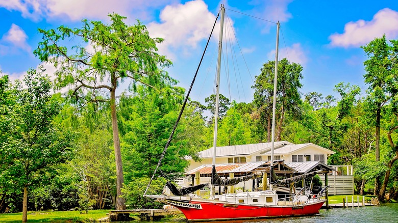 Red sail boat passing along the Magnolia River