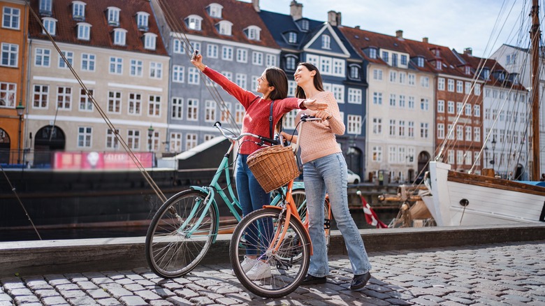 Two women smiling with bicycles