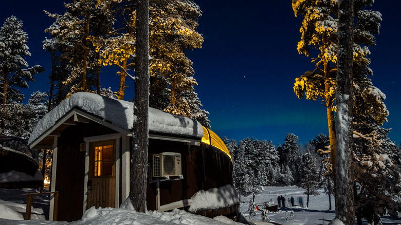 The Northern Lights shine over a house in Lapland, Finland