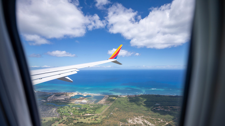 Wing of an airplane flying over Hawaii