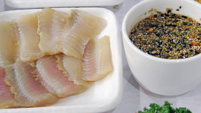 Raw plated hongeo-hoe next to a ramekin of sauce