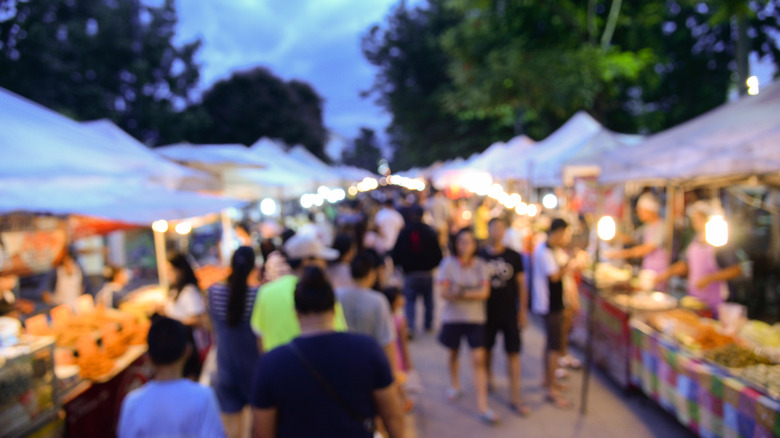 People walking around night market stalls