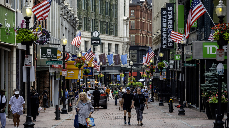 People walking on Summer Street in Boston with flags hanging