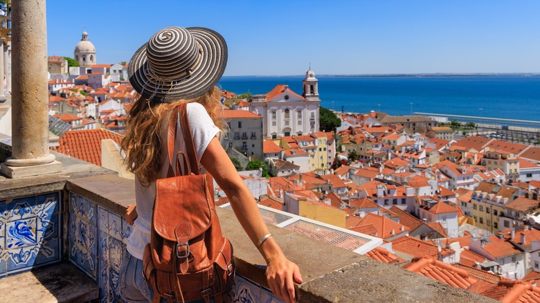 Woman in a hat looking at views of Lisbon
