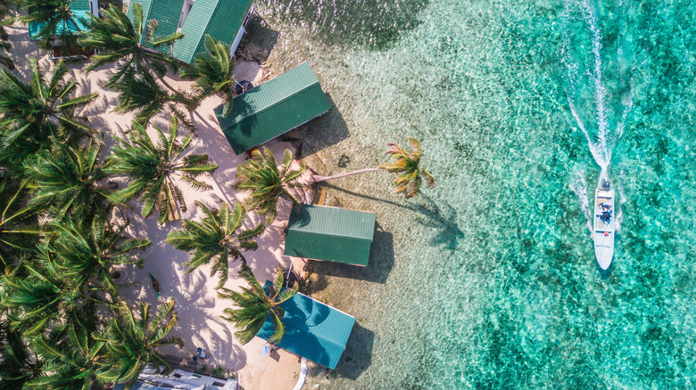 Aerial view of Tobacco Caye, over the water bungalows, and a boat